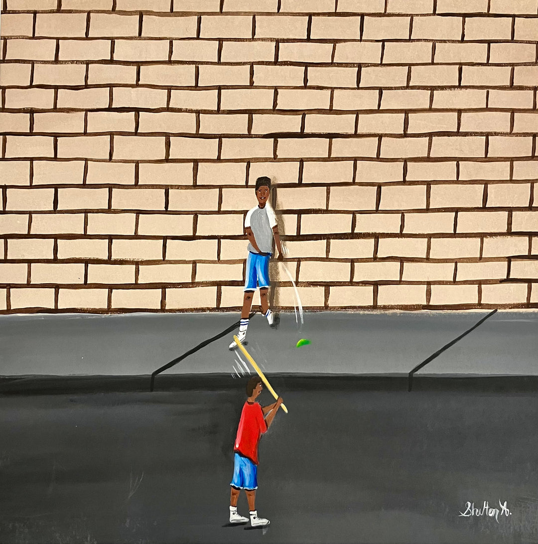 two boys playing outside game with stick and ball in street in front of brick wall