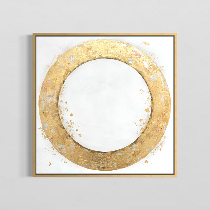 36X36 gold leaf circle on a slightly textured white background with gold and silver leaf dispersed throughout framed in gold on a light grey wall