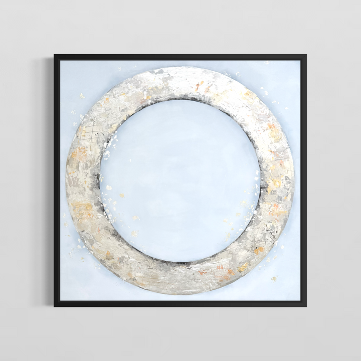 36X36 silver circle made with metallic and gold foil on a light grey acrylic background in a black frame on a grey wall