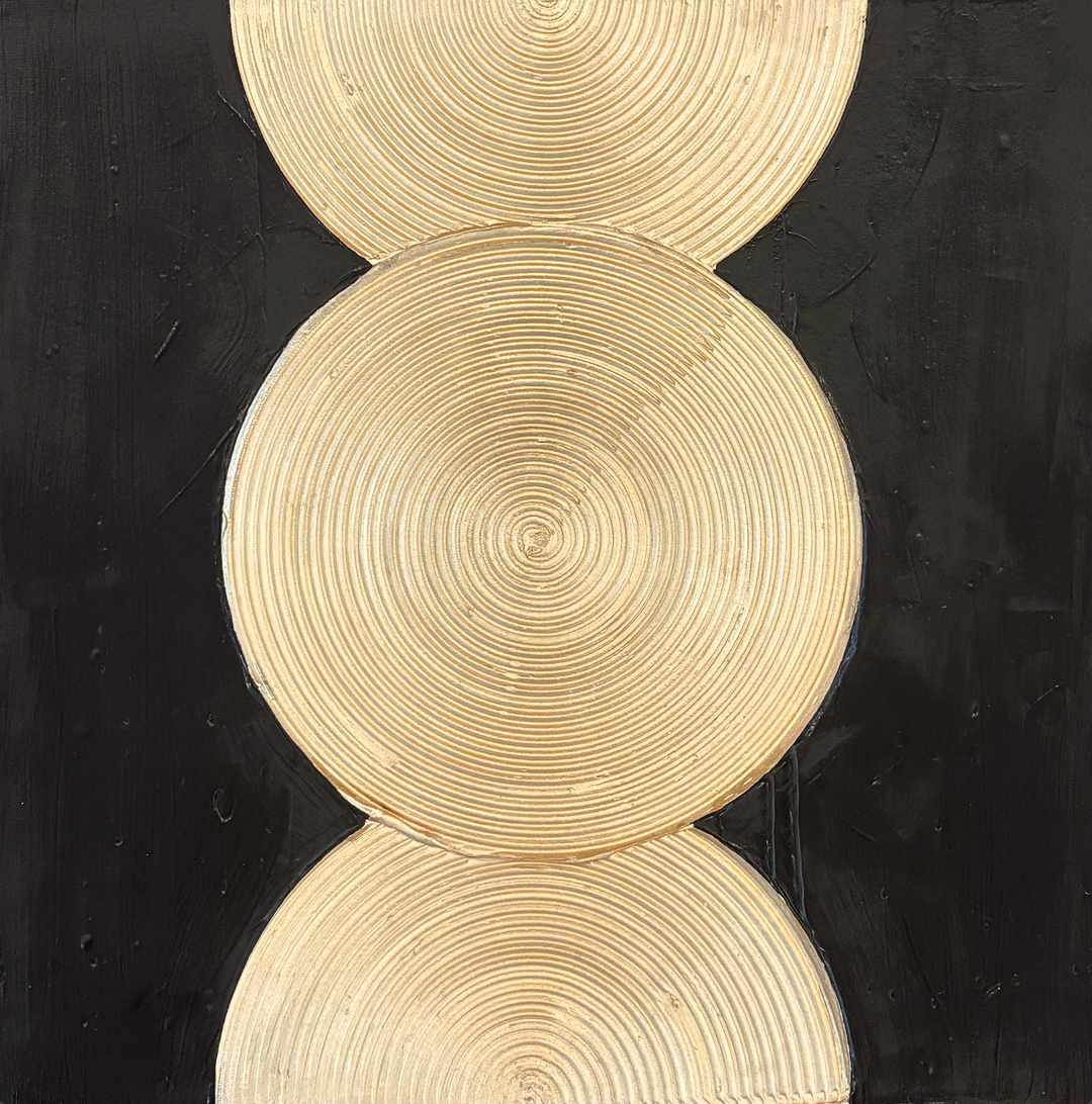 one circle and two half gold ridged circles in vertical orientation  on black background