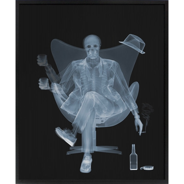 skeleton man xray sitting legs crossed  in chair with cigarette botles and glass on black background moves as you walk past lenticular