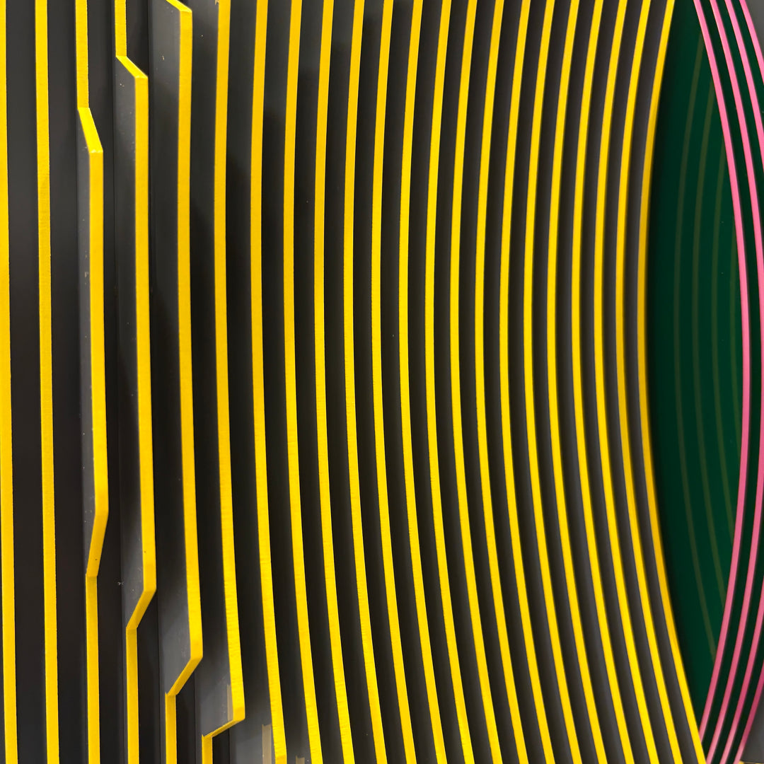 vertical stripes in black and yellow with circle in center offset optical illusion stripes with pink purple stripe down the middle