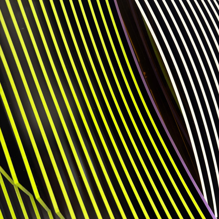 vertical stripes in black and yellow with circle in center offset optical illusion stripes with pink purple stripe down the middle