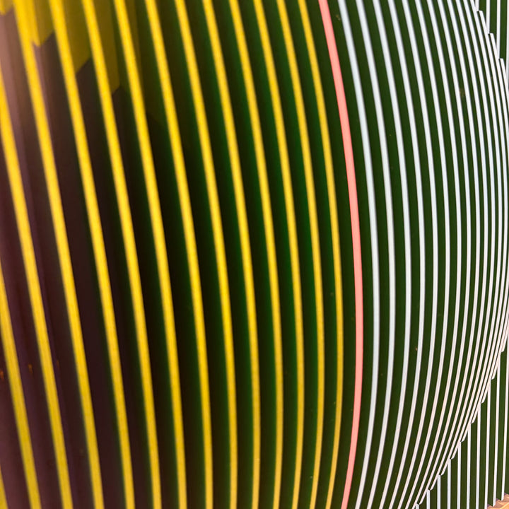 vertical stripes in green and blue with half split background in triangles on green and blue circular shape con-vexing sculptural out of center composition one pink line in middle