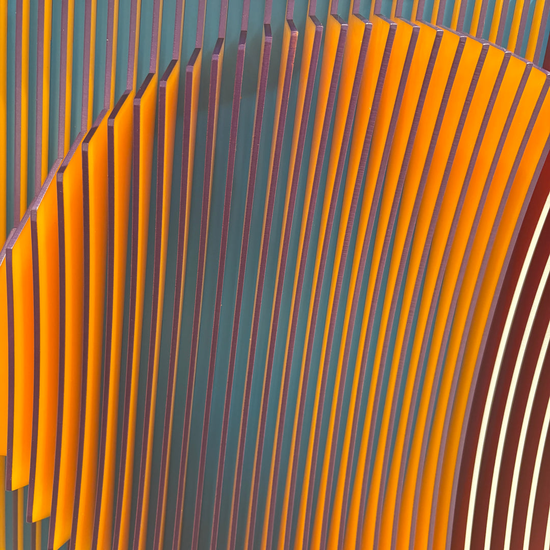vertical stripes plexiglass abstract geometric with yellow and orange in back and pulsing round circular middle in blue when viewed at angle mostly red