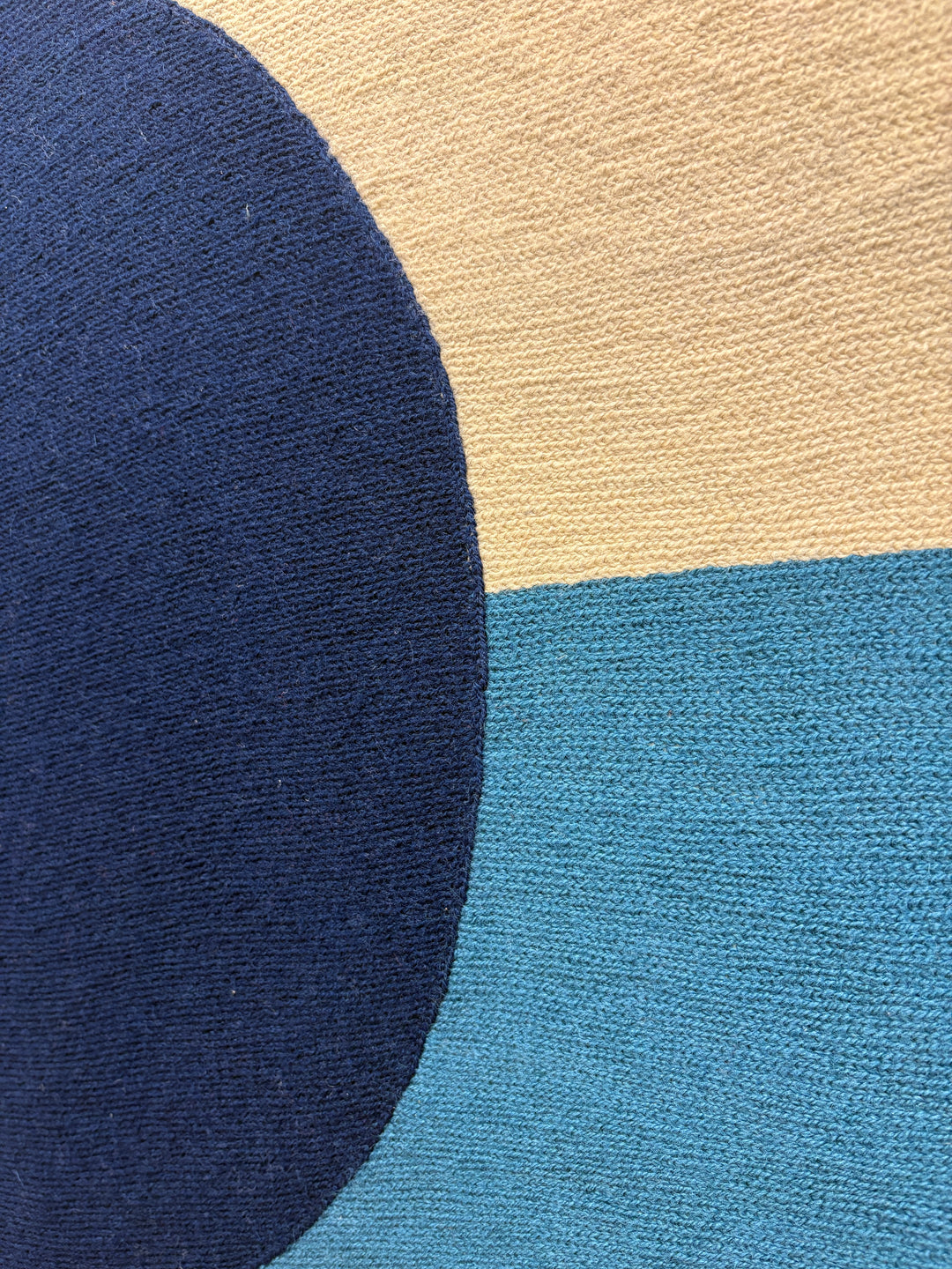 chain stitched embroidery textile fabric framed abstract geometric blue dot split composition negative space white and blue with orange wave in foreground