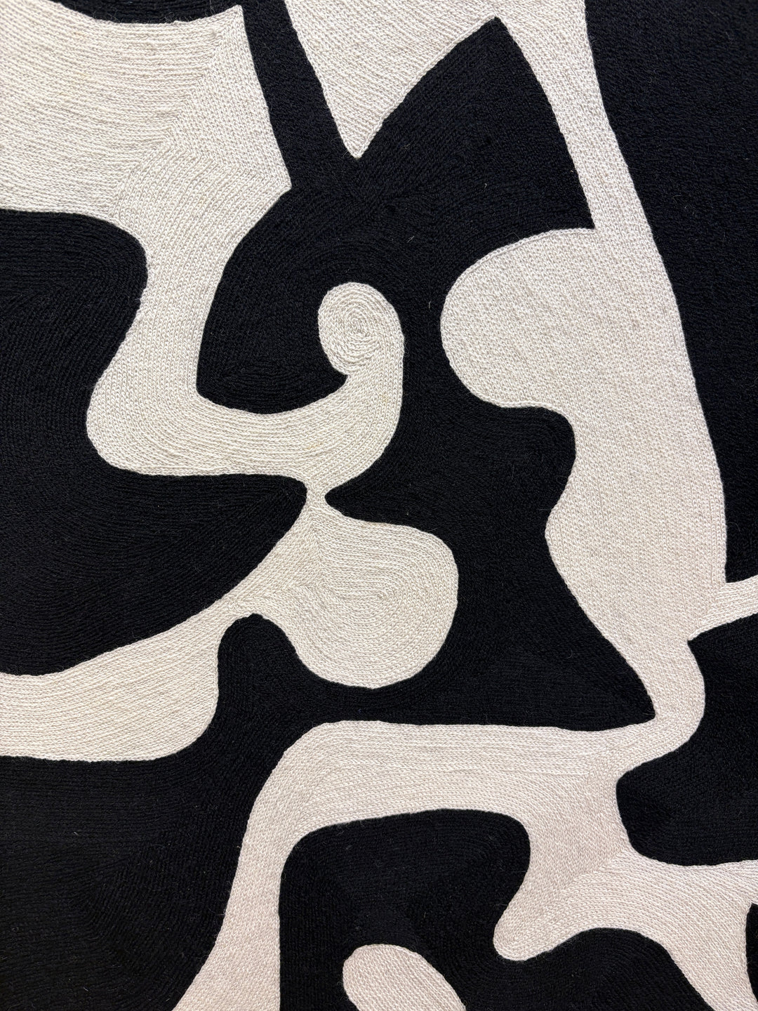 chain stitched textile embroidery abstract black and white negative space pattern shapes in wood frame