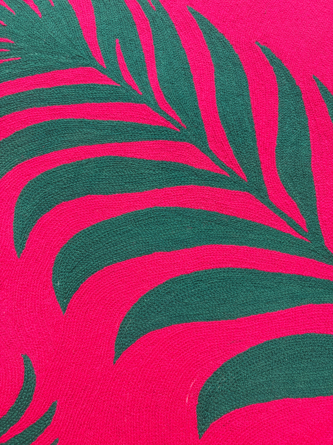 42.5"x42.5" chain-stitched textile with two tropical leafs over a bright pink background. 
