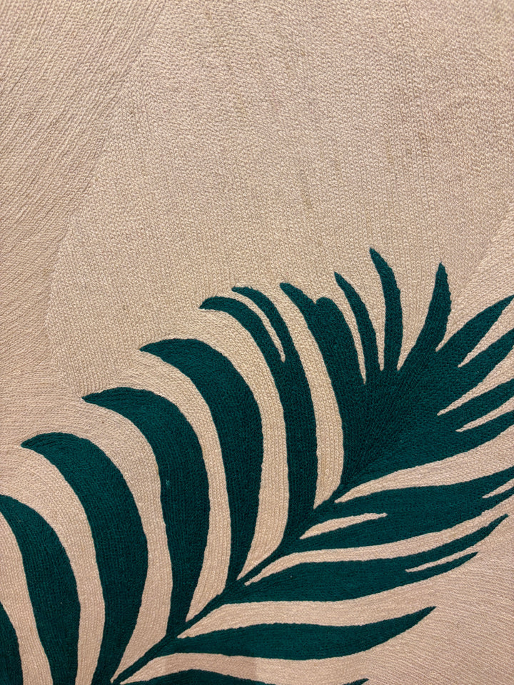 Two green palm fern leaves green on cream tan background in stitched embroidery chain textile fabric 