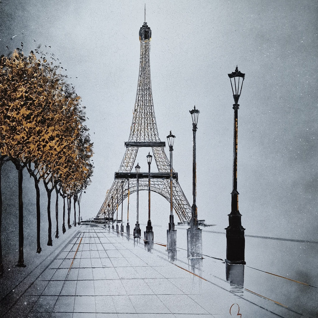 "In Paris" by French artist Julien Rey — a mixed-media painting on board of the Eiffel Tower from a Parisian boulevard, crafted with Chinese lacquer and gold leaf. A tree-lined avenue with classic street lamps leads the eye toward the iconic iron tower, its structural details accented in gold leaf. Autumn trees with luminous gold foliage frame the misty silver-gray composition. Original contemporary Eiffel Tower Paris painting on board available at Morton Contemporary gallery.