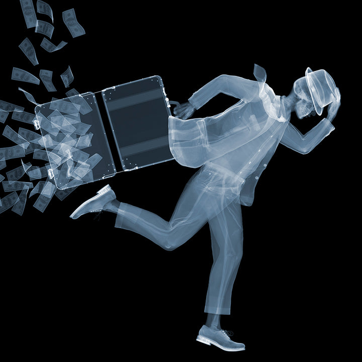 Framed Chromaluxe black and white x-ray photograph by Nick Veasey of a skeleton man in a fedora and suit running against the wind as his briefcase full of cash opens and the money blows away