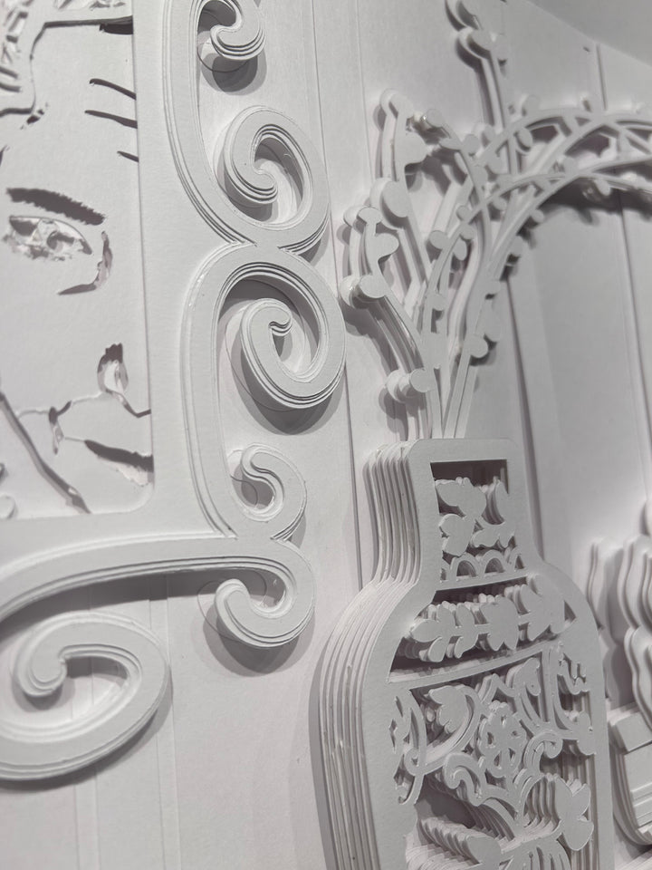 14"x14" layered white paper forming a vase with branches over a wall. 