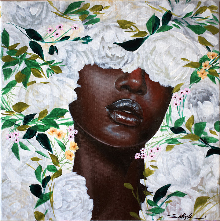 black woman facing viewer with white flowers and green leaves surrounding head 