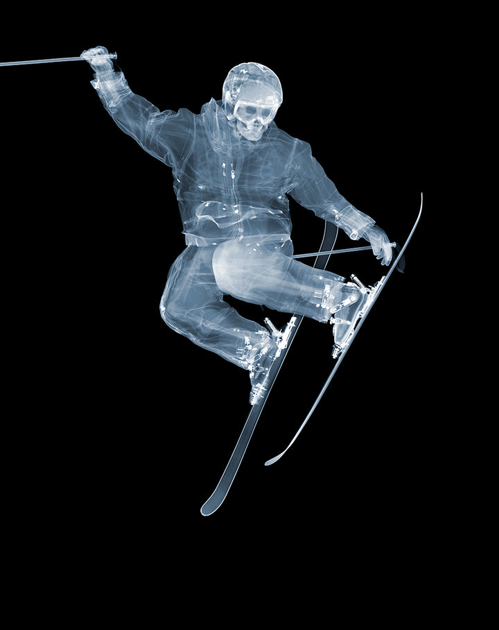 Framed Chromaluxe x-ray photograph by Nick Veasey of a skeleton skier jumping on a black background