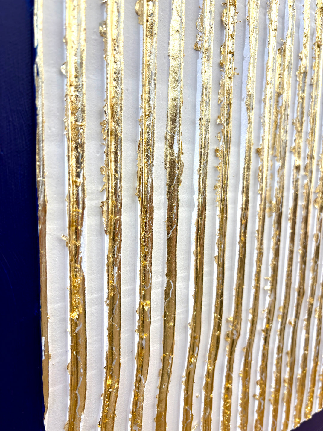 minimal geometric abstract sculptural work with joint compound texture dimension white rigid triangle with gold leaf detail on blue background