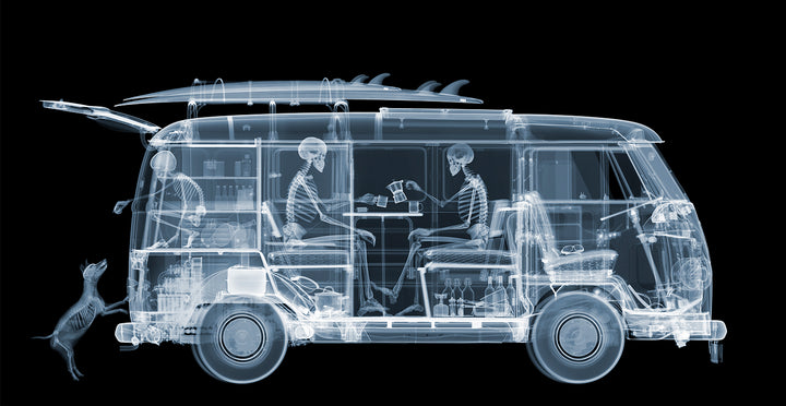 Framed Chromaluxe black and white x-ray photograph by Nick Veasey of a skeleton family sitting in a VW camper van with a surf board on top and a dog. 