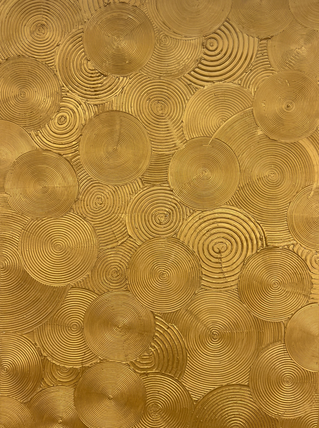 Visionary by Lee in Cerulean. Textured painting of gold circles, overlapping with smaller circles within creating a spiraled and whimsical effect.
