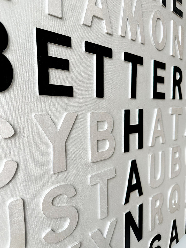 Contemporary 3D text artwork by Chicago artist Steffanie Gerkin titled Well Done 3D, featuring raised black and white wood letters arranged in a structured alphabet grid on a white canvas. The monochrome typographic composition spells the phrase “Well Done Is Better Than Well Said,” creating a bold conceptual wall art piece with graphic text-based design, pop art influence, and contemporary mixed-media style.