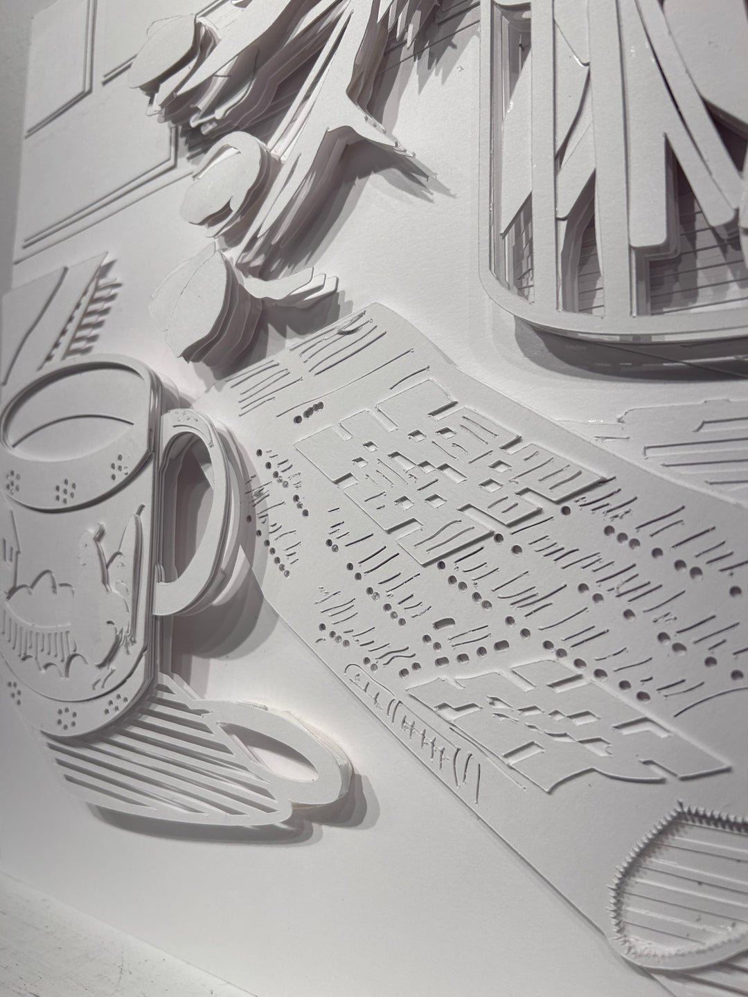 14"x14" paper cut collage featuring a coffee mug and crossword puzzle. 
