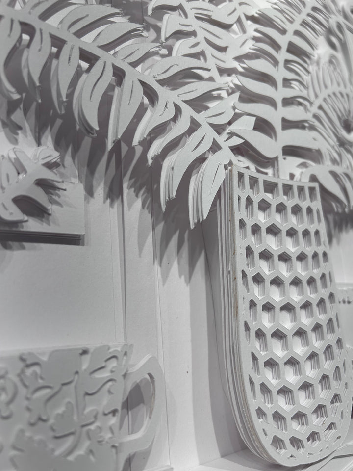 14"x14" layered white paper forming a vase with a fern over a wall.  