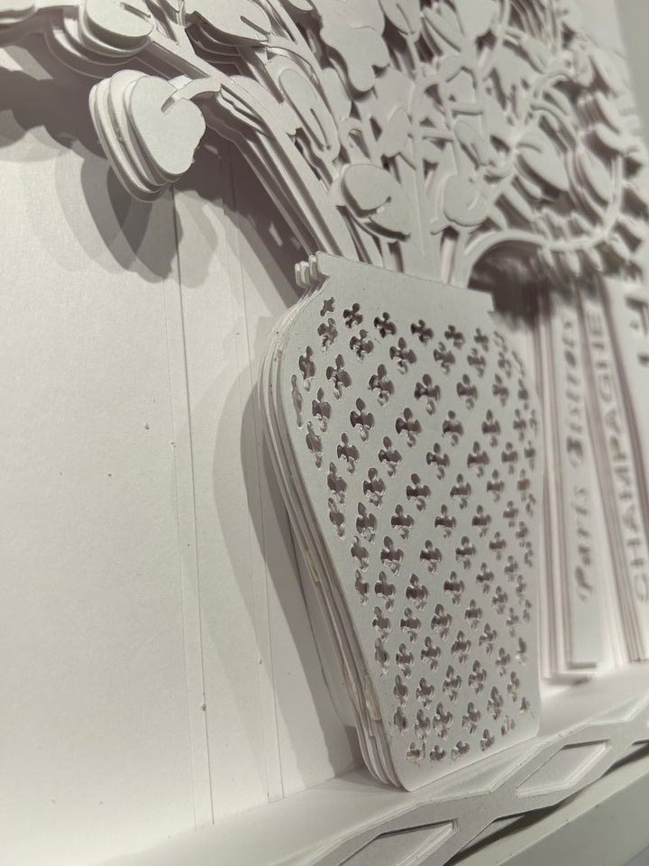14"x14" layered white paper forming a vase with a fern over a wall.  
