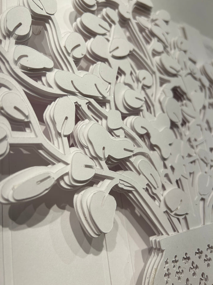 14"x14" layered white paper forming a vase with a fern over a wall.  