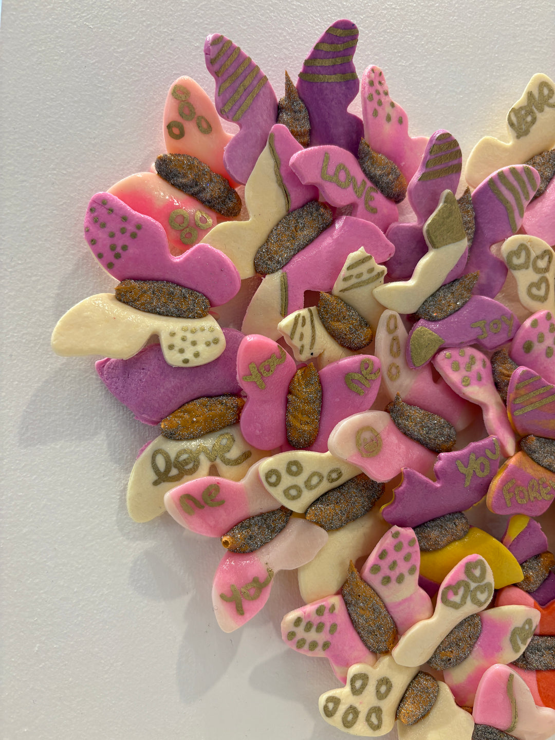 3 dimensional textured artwork of butterflies with text and floral collage on white background with pink and beige clay model paste acrylic in heart shape