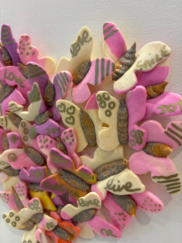 3 dimensional textured artwork of butterflies with text and floral collage on white background with pink and beige clay model paste acrylic in heart shape
