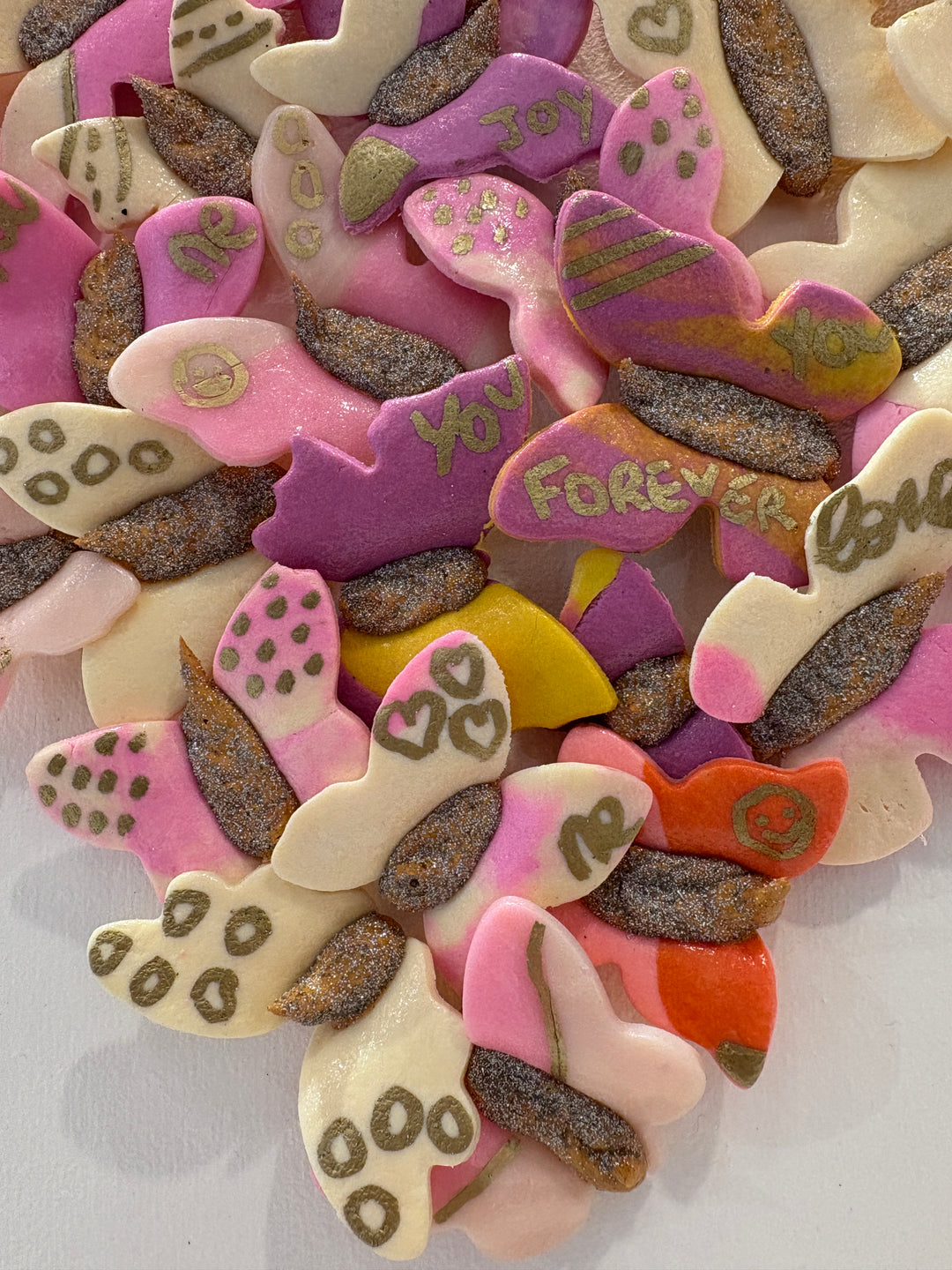3 dimensional textured artwork of butterflies with text and floral collage on white background with pink and beige clay model paste acrylic in heart shape